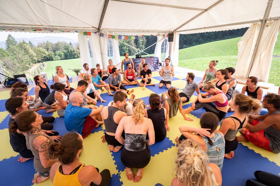 Big group discussion about safety in AcroYoga on the puzzle mats during our AcroYoga Retreat in Slovenia.
