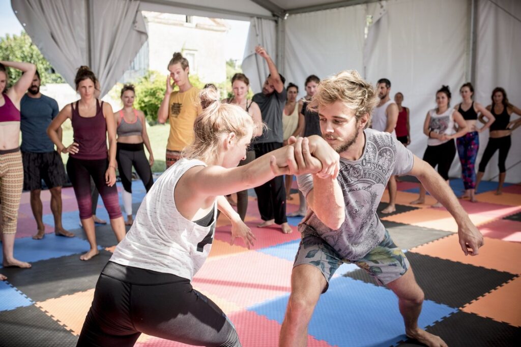demoing partner exercises during the acroyoga retreat on the mats