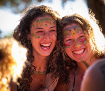 Girls with body paint laughing during an AcroYoga retreat in Croatia.