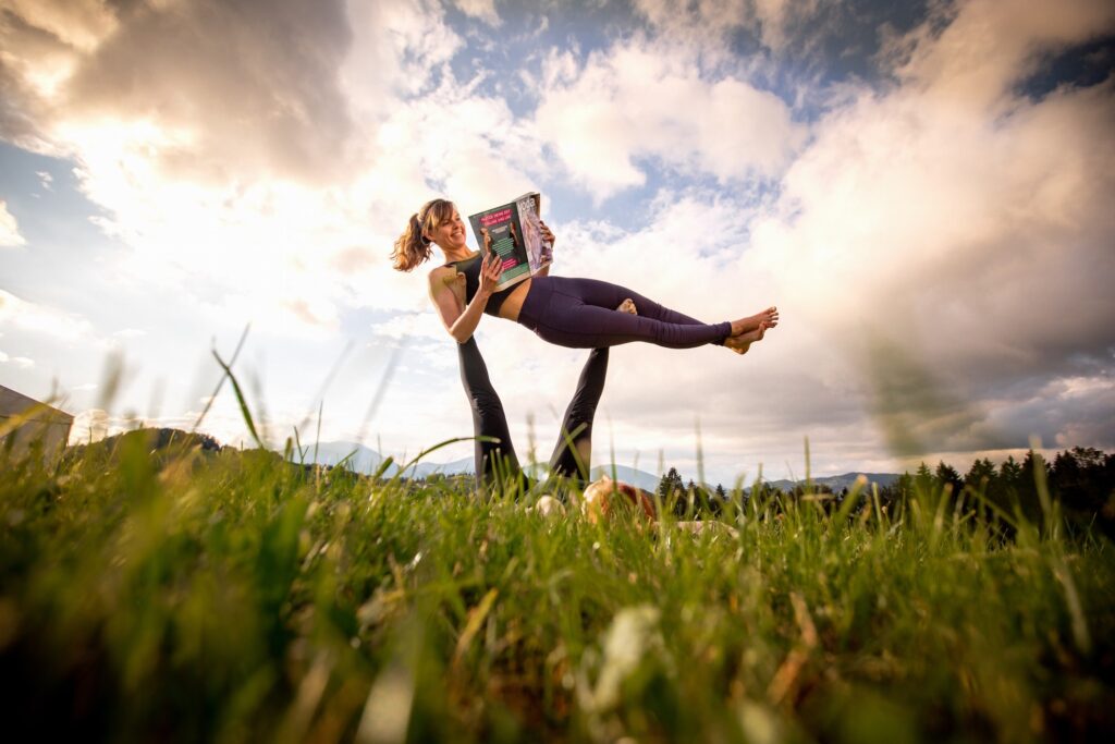 Girl reading a newspaper in an AcroYoga Pose