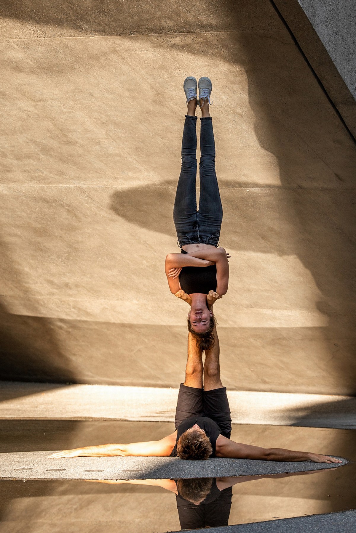 Girl being upside down balancing with a nice sunset in the city.